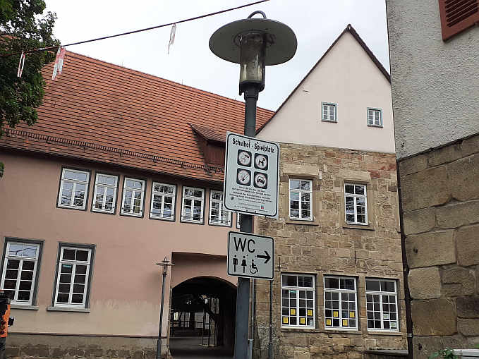 ... ein Schild weist den Weg zu den öffentlichen Toiletten (einschl. „Toilette für alle“ ) im Agneshof - zwischen Behördenzentrum und Waisenhofschule.