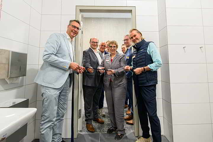 Landrat Dr. Richard Sigel und weitere Gäste der Eröffnungsfeier werfen einen Blick in die neue „Toilette für alle“ ...<br>Foto: © Heiko Potthoff
