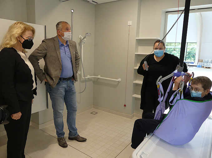 Vorbereitungen für das „Liften“ : Nina Stockinger prüft das Hebetuch, mit dessen Hilfe Jutta Pagel-Steidl „geliftet“ wird. Bürgermeister Ralf Steinbrenner und Marion Rathgeber-Roth (Landratsamt Heilbronn) schauen genau zu.<br />Foto: © Mara Sander