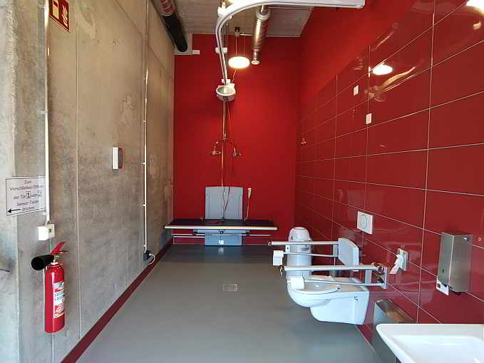 Die über 12 qm große Rollstuhl-Toilette im „Treff.26“ (Mühlgraben 26) ist zusätzlich ausgestattet mit einer höhenverstellbaren Wandklappliege für Erwachsene (mit abklappbarem Seitengitter), einem Deckenlifter (Hebetuch vorhanden) sowie einem luftdichten Windeleimer. Die „Toilette für alle“ ist mit dem Euro-Schlüssel rund um die Uhr zugänglich.